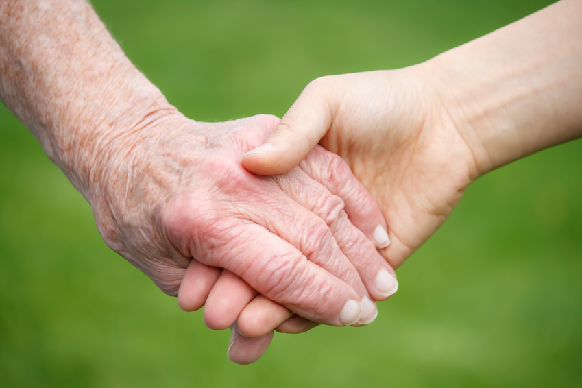 Photo of a Senior and Young Women Holding Hands