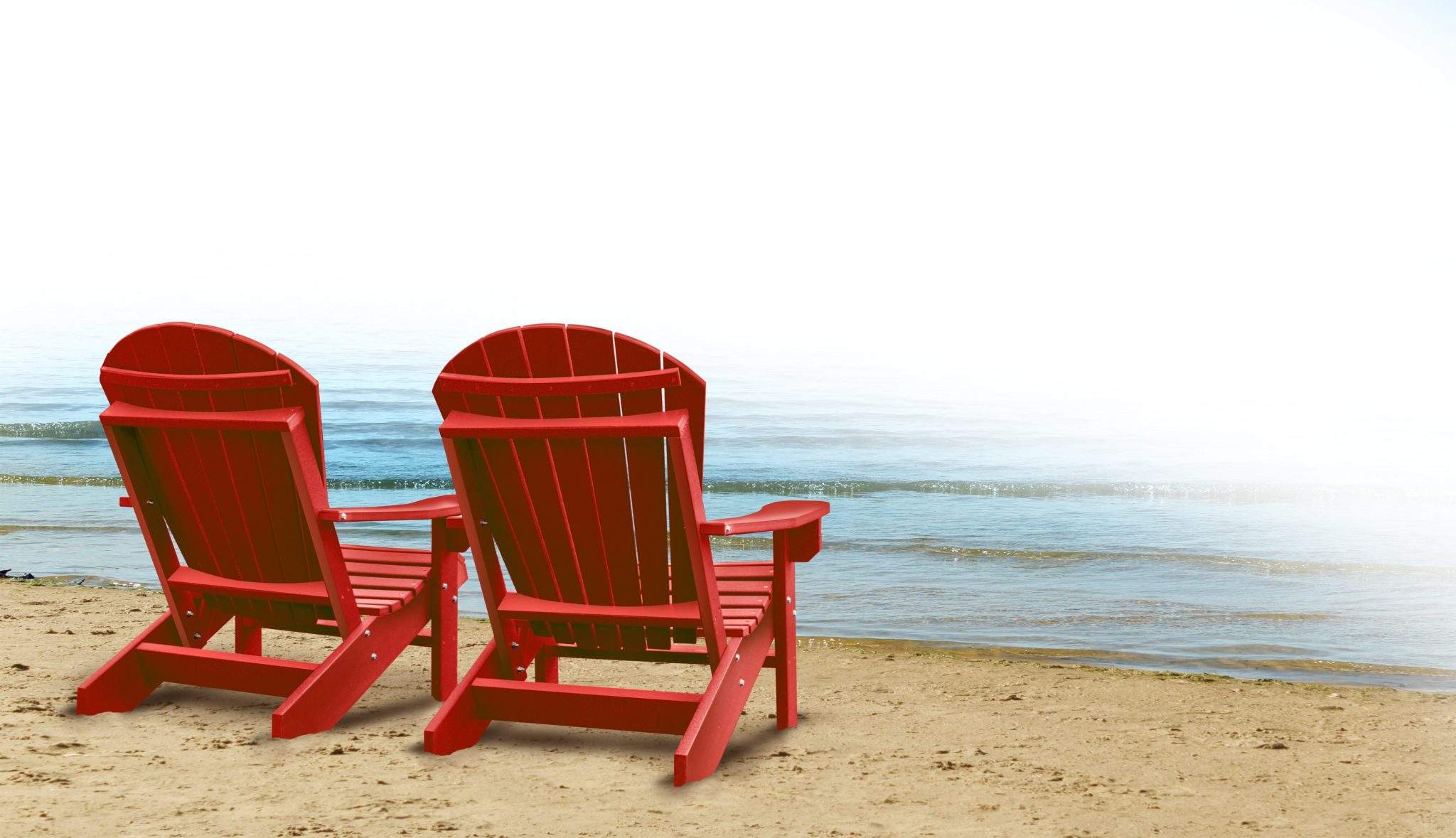 Photo of two red adirondack chairs sitting on the beach